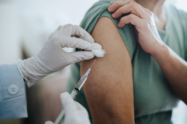 En person blir vaccinerad med en spruta i armen